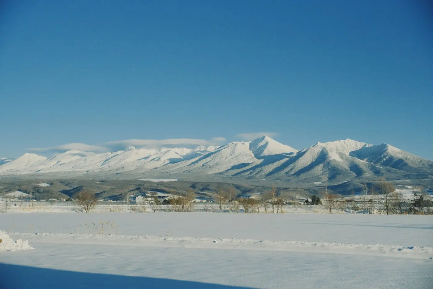 晴天下的北海道雪原與遠方雪山
